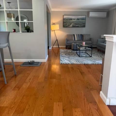 Hardwood floors shining after a Bolanta Carpet Cleaner deep clean, living room view
