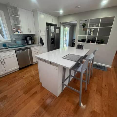 Spotless kitchen after a deep clean by Bolanta Carpet Cleaner — white cabinetry, island and gleaming hardwood floors